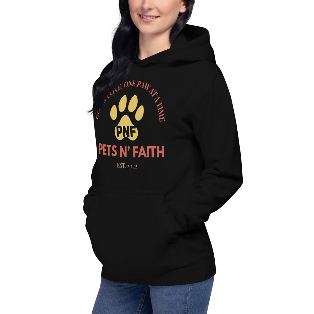 Woman wearing black Unisex Pets N’ Faith hoodie with yellow paw print and faith-inspired slogan
