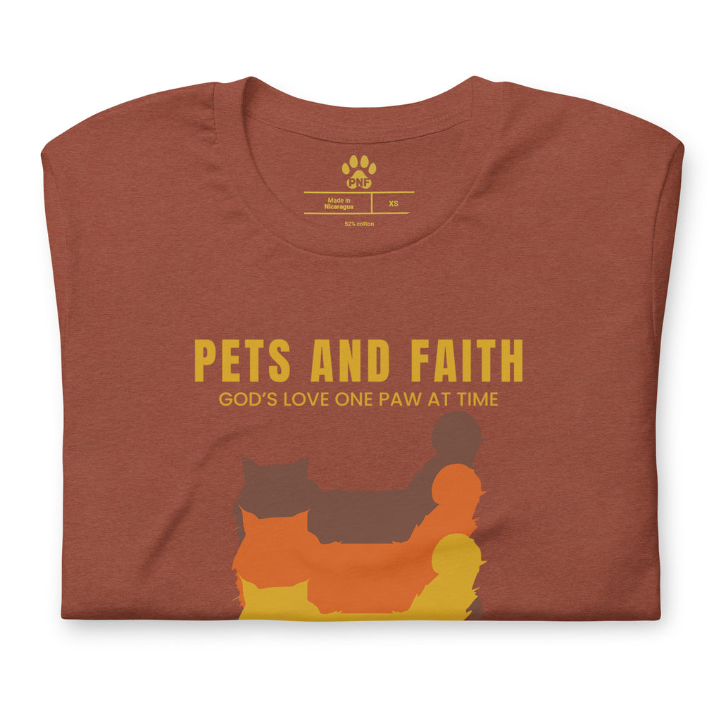 Folded view of autumn Pets N Faith unisex cat t-shirt with ‘God’s Love One Paw at a Time’ text and layered cat silhouette design