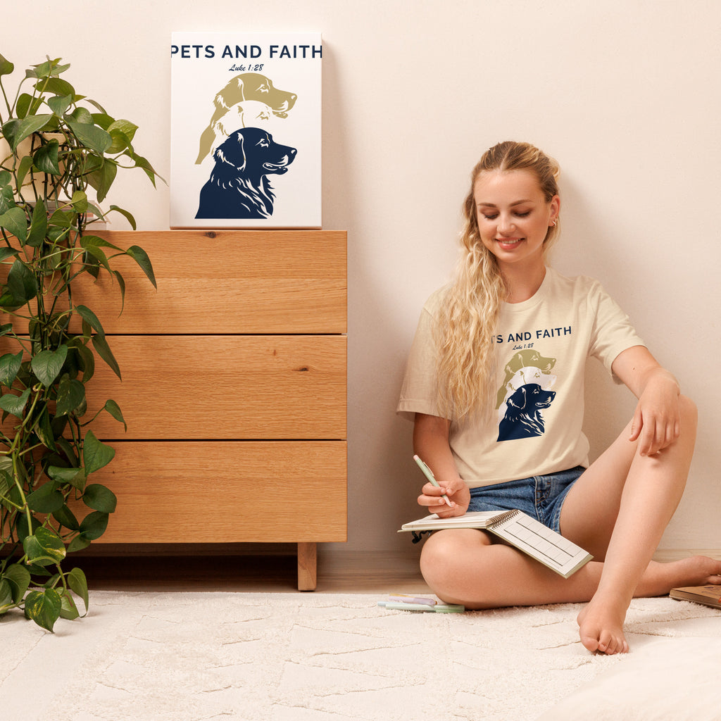 Women writing in journal wearing a Heather Natural Pets N Faith unisex dog t-shirt with Luke 1:28 scripture and layered dog silhouette design.