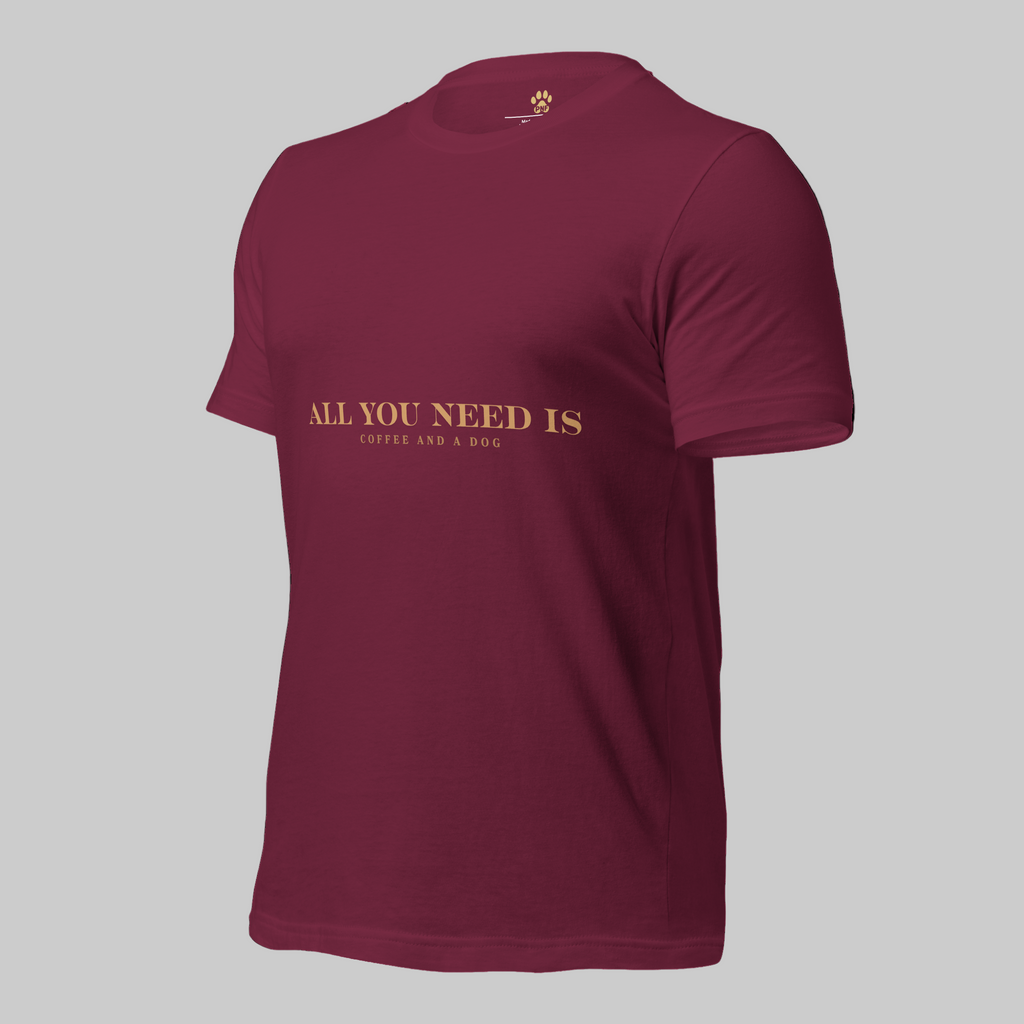 Maroon unisex T-shirt with the text ‘All You Need Is Coffee and a Dog’ in warm gold lettering