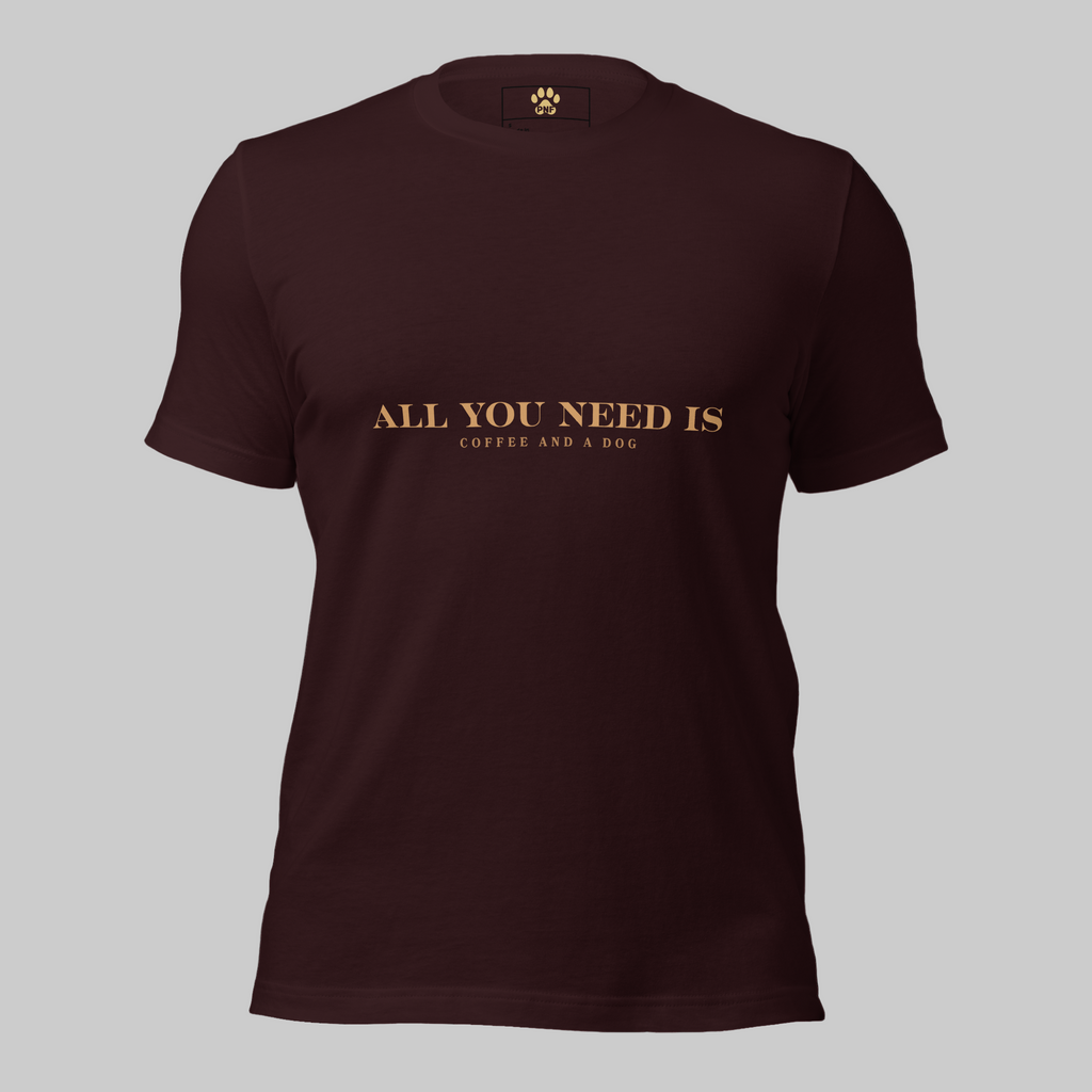 Oxblood unisex T-shirt with the text ‘All You Need Is Coffee and a Dog’ in warm gold lettering