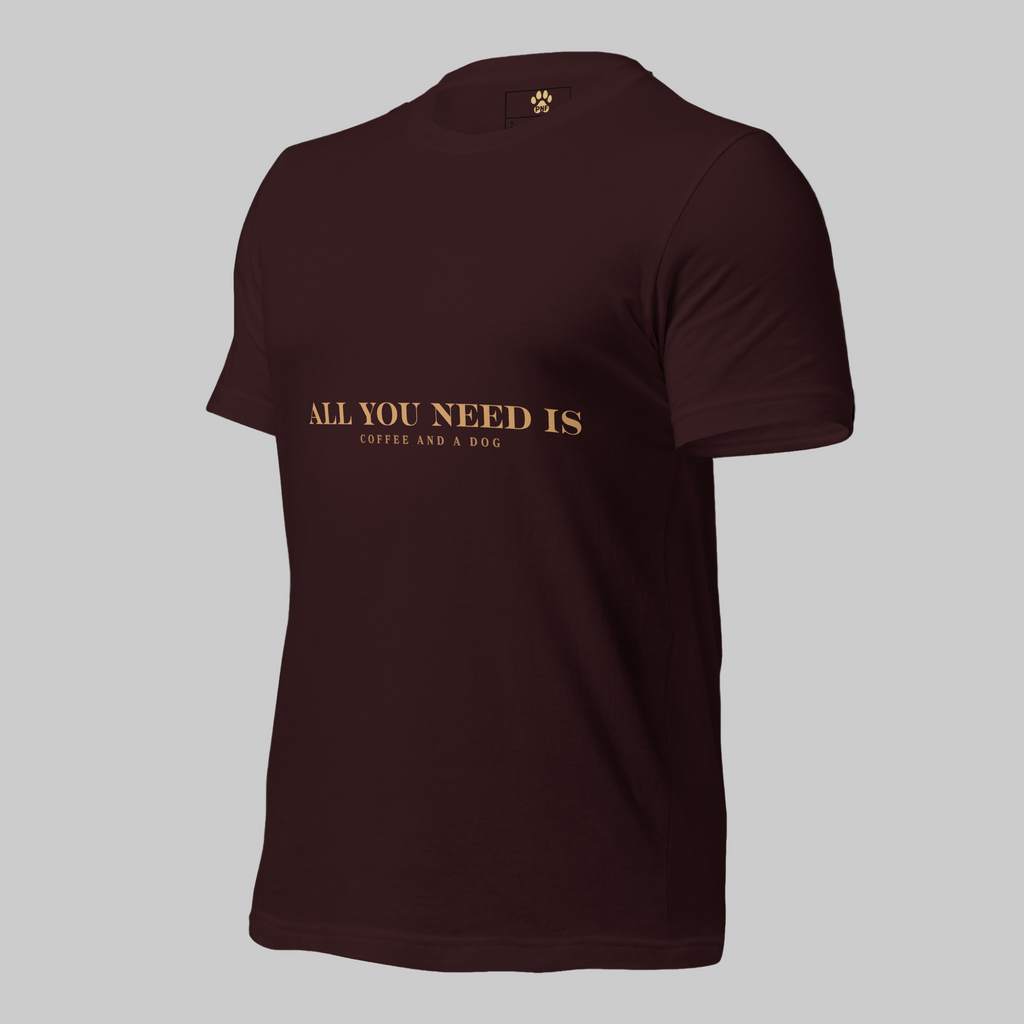 Oxblood unisex T-shirt with the text ‘All You Need Is Coffee and a Dog’ in warm gold lettering