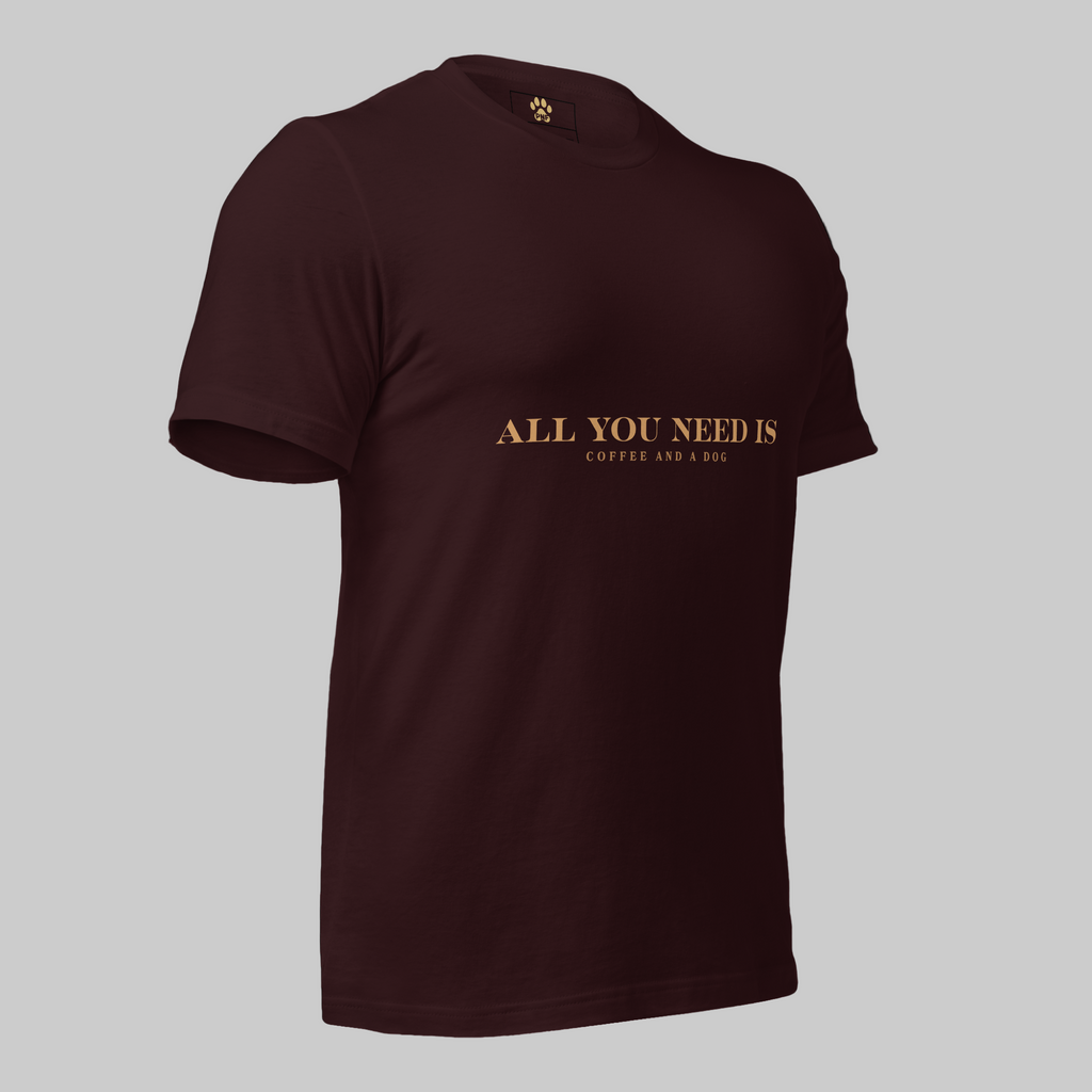 Oxblood unisex T-shirt with the text ‘All You Need Is Coffee and a Dog’ in warm gold lettering