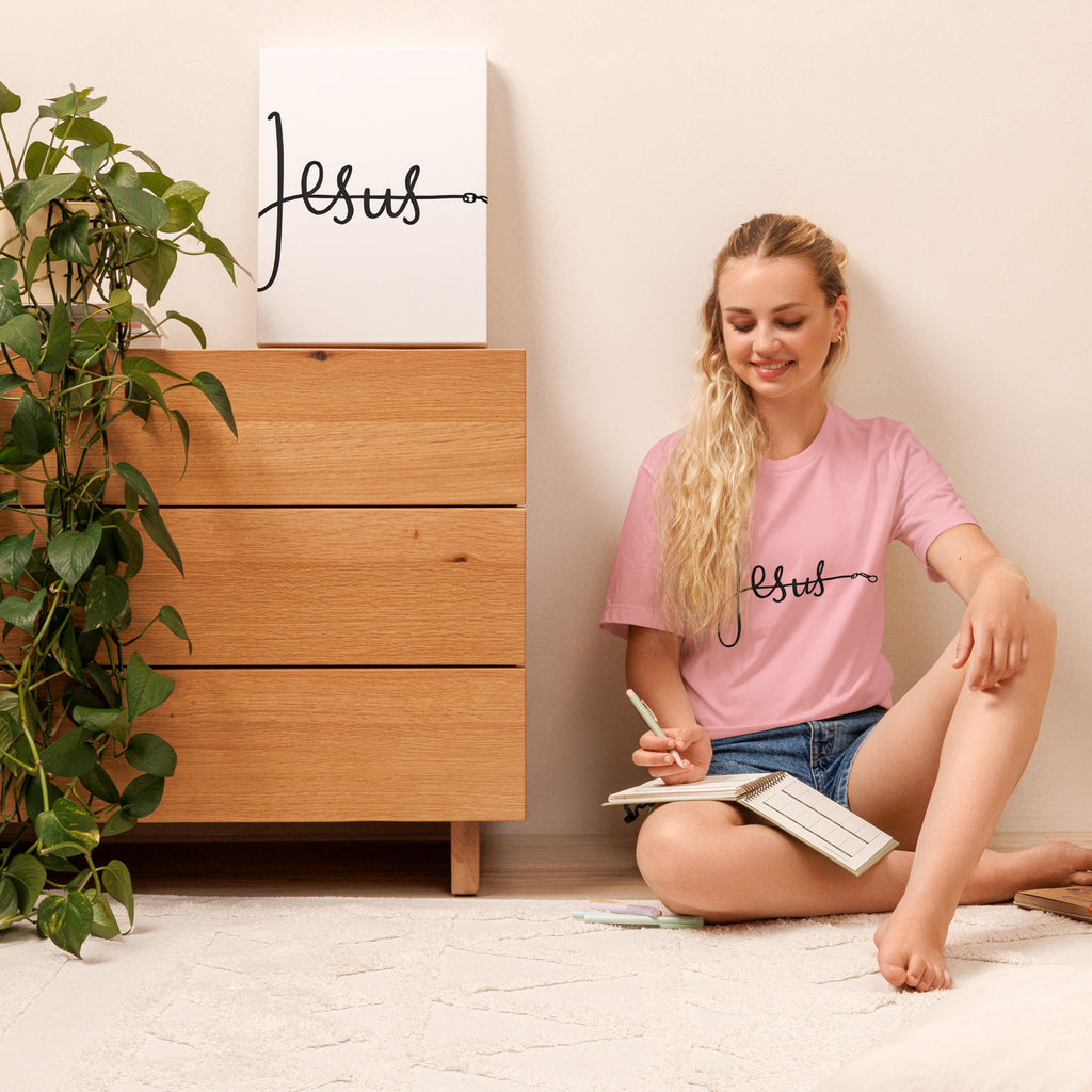 Pink unisex T-shirt with the word ‘Jesus’ in a flowing script design