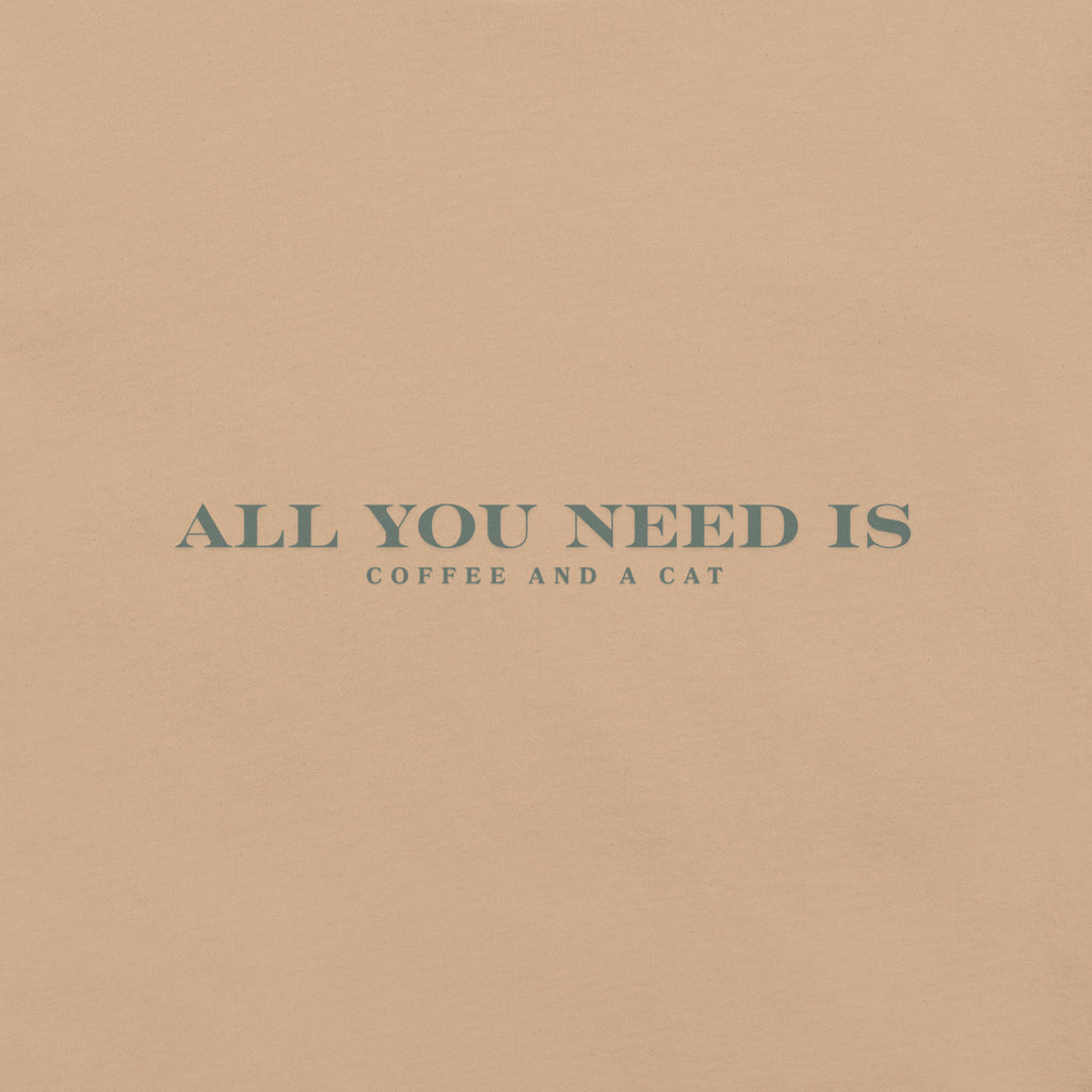 Tan unisex T-shirt with teal text reading ‘All You Need Is Coffee and a Cat