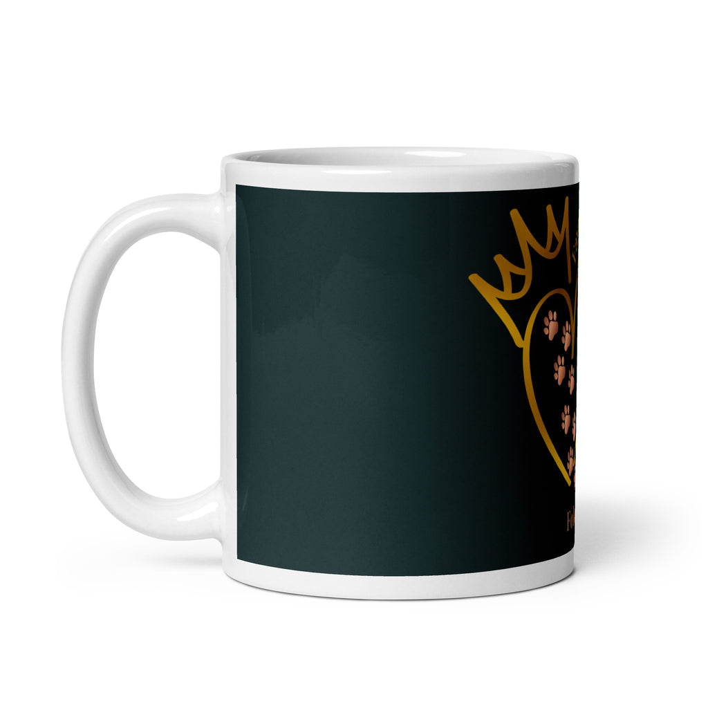 Side view of white glossy mug with a teal background. The graphic is a gold heart with a gold crown on top. The phrase is, " Favored by Jesus, Followed by Paw prints".  Small pet paw prints are walking through the heart graphic. 
