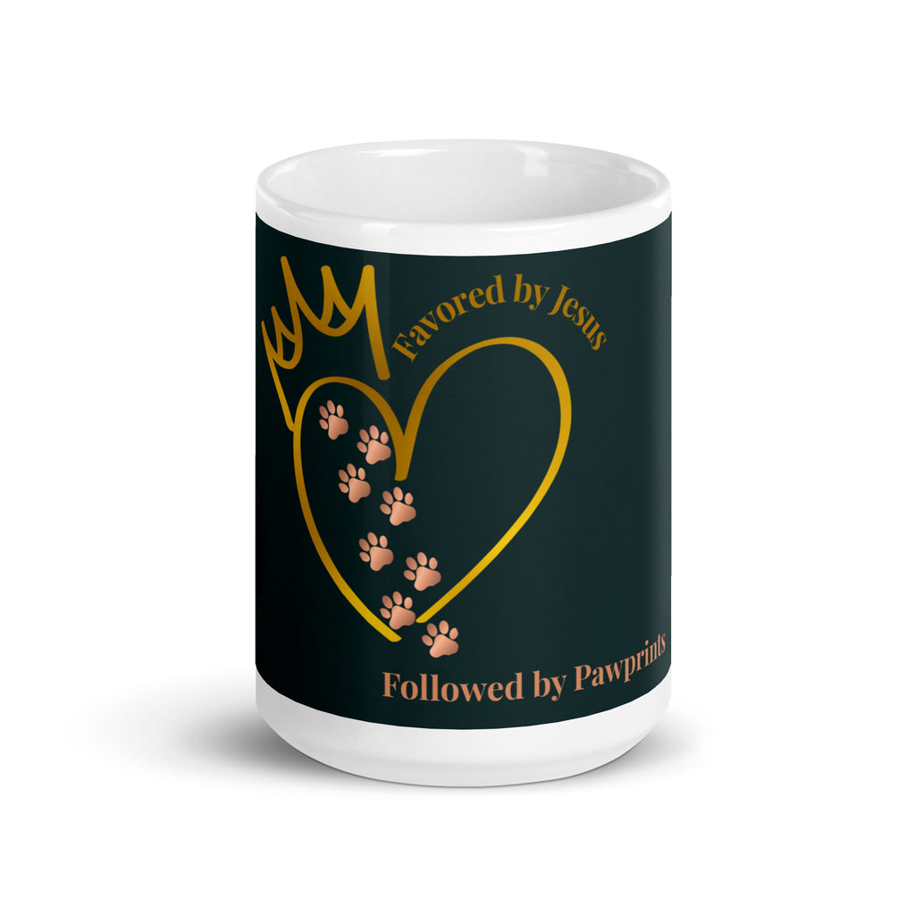 White glossy mug with a teal background. The graphic is a gold heart with a gold crown on top. The phrase is, " Favored by Jesus, Followed by Paw prints".  Small pet paw prints are walking through the heart graphic. 