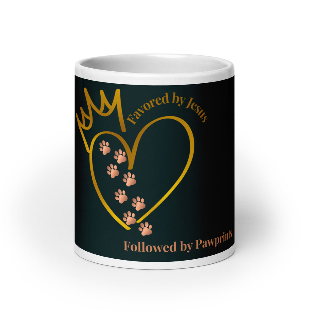 White glossy mug with a teal background. The graphic is a gold heart with a gold crown on top. The phrase is, " Favored by Jesus, Followed by Paw prints".  Small pet paw prints are walking through the heart graphic. 